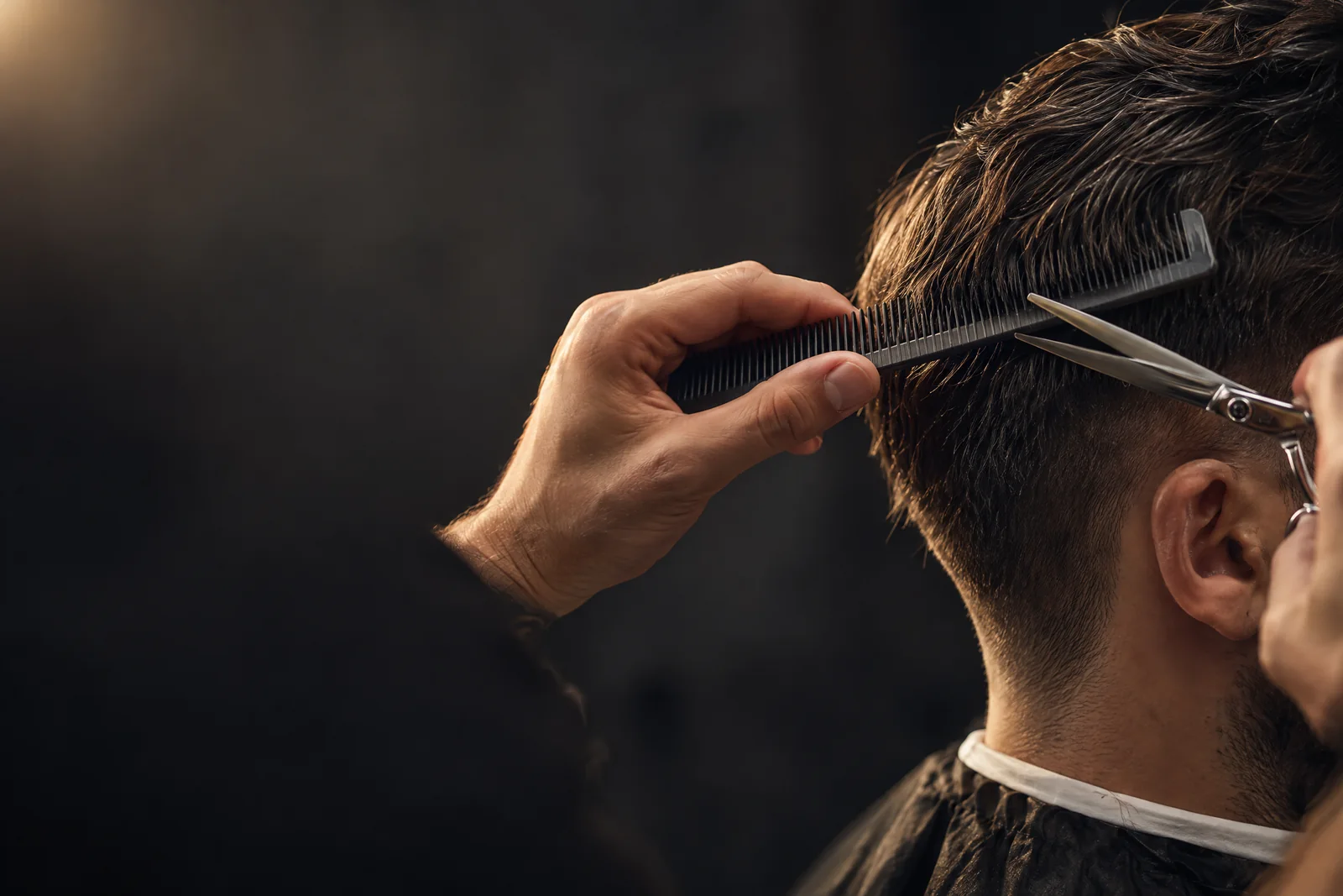 Barber verfeinert mit Kamm und Schere einen Haarschnitt